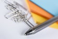 Coloured paper with paperclips and a pen Royalty Free Stock Photo