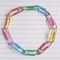 Coloured paperclips in a circle on lined paper