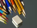 Coloured pencils and eraser on the mirror surface. Royalty Free Stock Photo