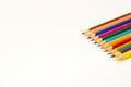 Coloured pencils on white background flat lay, close up. Royalty Free Stock Photo