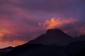 Coloured purple violet sunset at the muntain with white clouds above - beautiful mounts landscape with amazing colors - concept of
