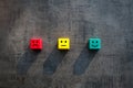 Coloured red yellow green wood cubes with faces to measure customer satisfaction -Business feedback concept