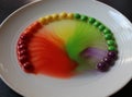 Coloured sweets in water make rainbow