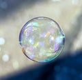 Coloured translucent soap bubble floating in the air Royalty Free Stock Photo