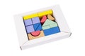 Coloured wooden figures in box on white background. Childrens building blocks. Geometric shapes. The concept of logical thinking