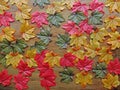 Colourful autumn artificial leaves scattered over wooden background Royalty Free Stock Photo