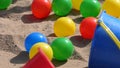Colourful balls buckets and spades in childs sand pit