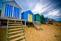 Colourful beach huts with dramatic sky