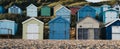 Colourful beach huts on a pebble beach in Milford on Sea, UK, selective focus Royalty Free Stock Photo