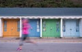 Colourful beach huts with runner in front, located on the promenade on the Bournemouth UK sea front. Royalty Free Stock Photo