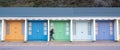 Colourful beach huts with runner in front, located on the promenade on the Bournemouth UK sea front. Royalty Free Stock Photo