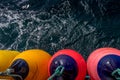 Colourful boat fenders and water