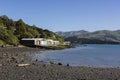 Colourful boat sheds on stony shoreline