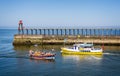 Colourful boats crossing on way in to Whitby harbour