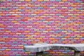 Colourful brick wall pattern background and texture with wooden bench