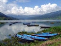 Colourful rowing boats on Phewa Lake, Pokhara, Nepal with mountains Royalty Free Stock Photo