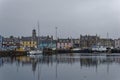 Colourful Buildings line the Waterfront behind the Fishing Boats moored up beside the Stone wharves of Stornoway