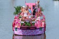 Colourful canal parade of flower and vegetables decorated boats with cheerful dressed up singing and dancing people