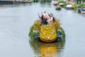 Colourful canal parade of flower and vegetables decorated boats with cheerful dressed up singing and dancing people