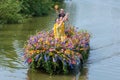 Colourful canal parade of flower and vegetables decorated boats with cheerful dressed up singing and dancing people