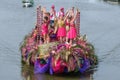 Colourful canal parade of flower and vegetables decorated boats with cheerful dressed up singing and dancing people