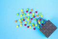 Colourful candy and polka dot paper bag on blue background Royalty Free Stock Photo