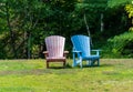 Colourful chairs at a park with trees in the background