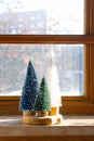 Colourful Christmas trees on the window. Trendy home decor for winter holidays Royalty Free Stock Photo