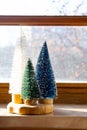 Colourful Christmas trees on the window. Trendy home decor for winter holidays Royalty Free Stock Photo