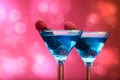 Colourful cocktails garnished with berries, background with light effects