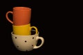 Colourful coffee mugs on a black background