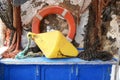 Traditional fishing equipment of life saver ring, weight, ropes and nets on blue wooden chest Royalty Free Stock Photo