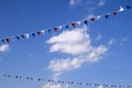 Colourful decorative triangular flags under blue sky with clouds Royalty Free Stock Photo