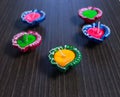 5 Colourful Diyas/Lamps arranged in diffrent ways on table to celebrate diwali