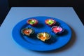 5 Colourful diyas placed on a blue plate