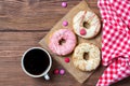 Colourful donuts, smarties and cup of coffee, wooden background, top view Royalty Free Stock Photo