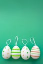 Colourful easter eggs with a hanger on a green background with soft shadows