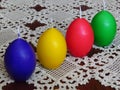 Colourful egg shaped candles on handmade table cloth in crochet.Easter home decoration.