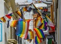 Colourful flags hang in a line on a street.