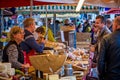 Colourful French cheese market stall with market trader and customers taken in Beaune, Burgundy, France