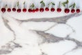 Colourful fresh bright pattern with ripe red cherry and leaf on marble table. Top view, flat lay Royalty Free Stock Photo