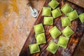 Colourful fresh ravioli with spinach on Board with flour