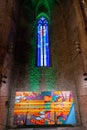 Colourful glass window inside Basilica Santa Maria del Mar with a modern painting in the lower part. Barcelona