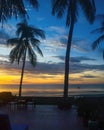 Colourful gold and blue stratocumulus cloudy exotic tropical sunrise seascape with Palm Trees in silhouette