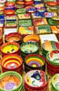 Colourful hand painted bowls and pots arranged in rows on market