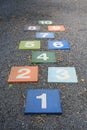 Colourful hopscotch playground markings numbers on stone at Pavement