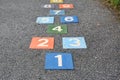 Colourful hopscotch playground markings numbers on stone at Pavement