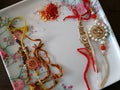 A close up shot of two colorful threads called as Rakhis arranged on a white plate