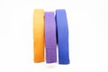 Colourful karate belt of yellow, purple and blue on white background Royalty Free Stock Photo