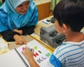 Colourful letters on the book as reference for the child to type into the braille typwriter